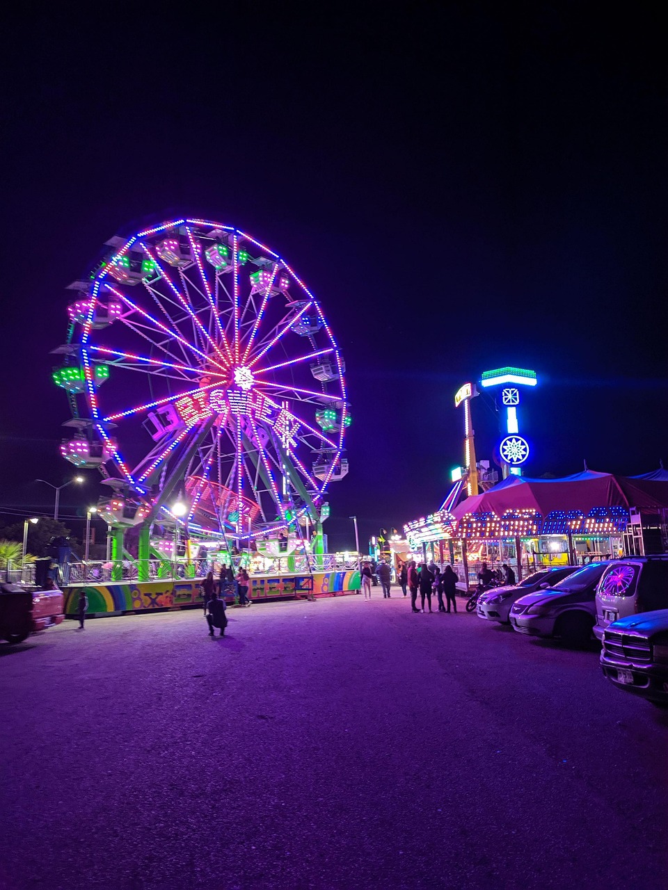 Beleuchtetes Riesenrad bei Nacht auf einem Rummelplatz